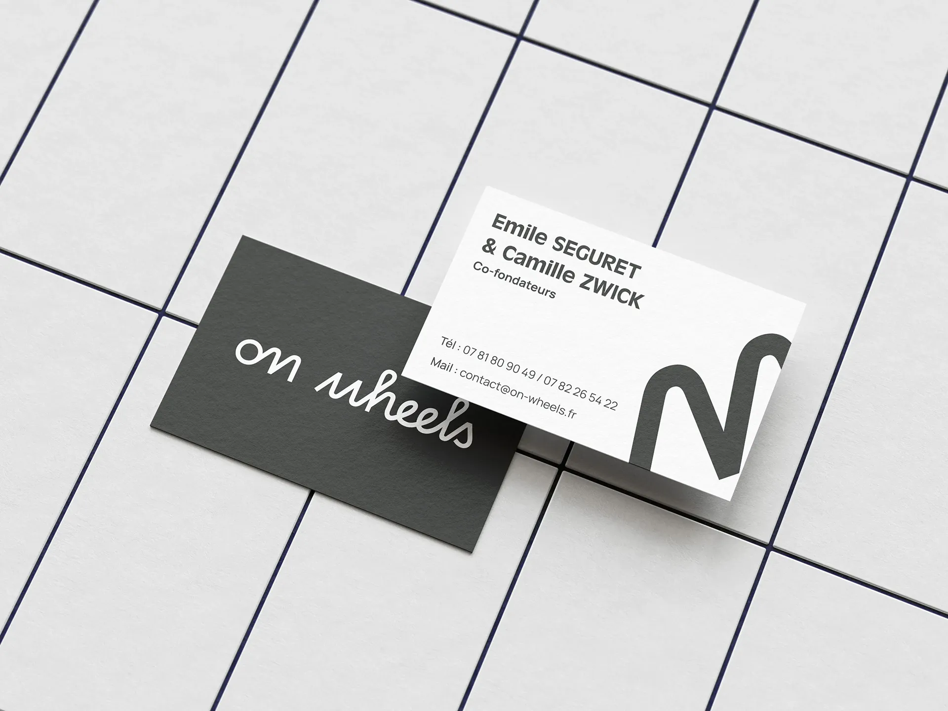 Mockup de cartes de visite On Wheels avec logo, coordonnées des cofondateurs et identité visuelle de la marque.